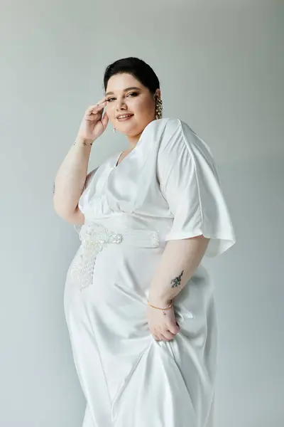 Una impresionante novia de tamaño grande irradia belleza en su vestido blanco que fluye con detalles de perlas y pendientes brillantes. — Stock Photo