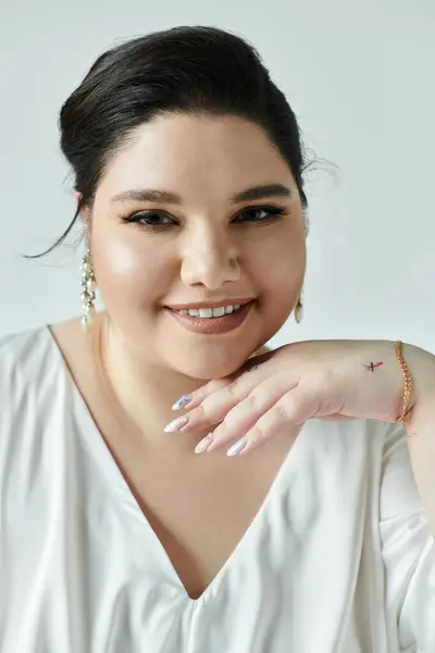 A stunning plus size bride showcases her elegance in a flowing white gown, adorned with sparkling earrings. — Stock Photo
