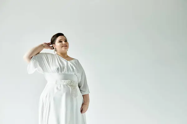 A radiant plus size bride proudly showcases her beautiful white wedding dress and exquisite earrings. — Stock Photo