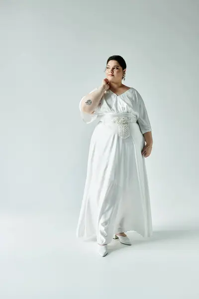 A radiant plus size bride showcases her beauty in a flowing white wedding dress and shimmering earrings. — Stock Photo