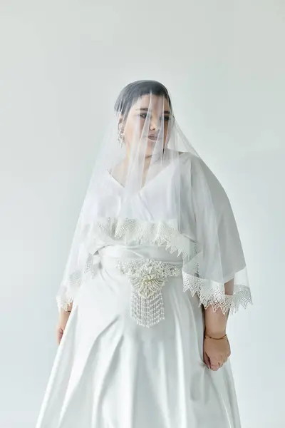 A beautiful plus-size bride showcases grace in her stunning white gown and delicate earrings. — Stock Photo