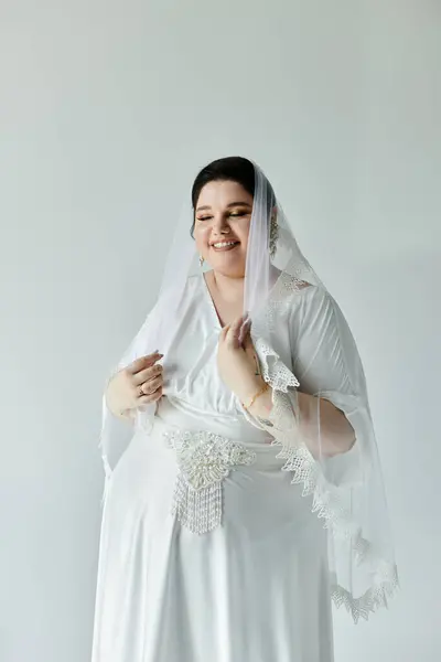 A joyful bride in a flowing white gown and delicate earrings embraces her special moment with grace. — Stock Photo