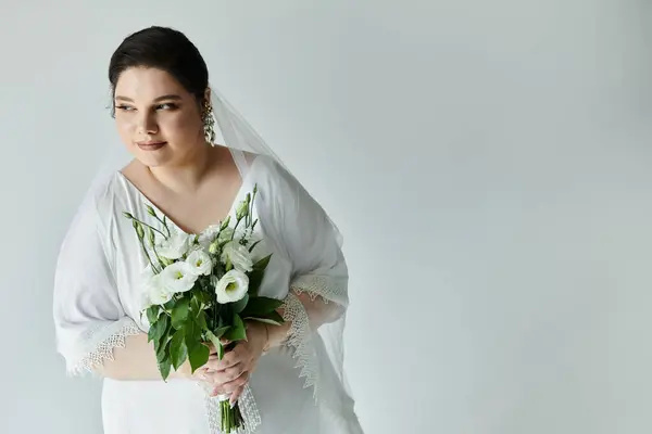 A radiant bride showcases her beauty in a flowing gown, adorned with elegant earrings and a bouquet of white flowers. — Stock Photo