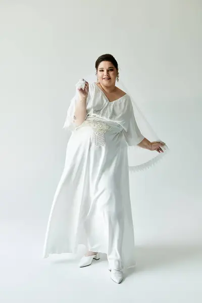 A radiant bride showcases her beauty in a flowing white gown, playfully twirling and smiling. — Stock Photo