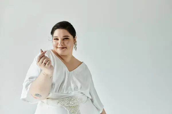 Uma noiva radiante celebra sua beleza em um vestido branco deslumbrante e brincos elegantes. — Fotografia de Stock