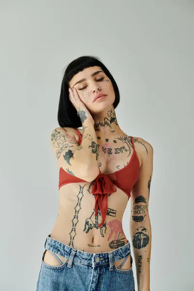 A fashionable woman with intricate tattoos poses thoughtfully, showcasing her style. — Stock Photo