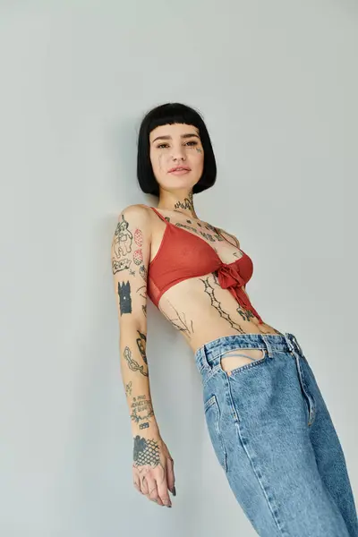 A stylish woman poses confidently against a simple wall backdrop. — Stock Photo