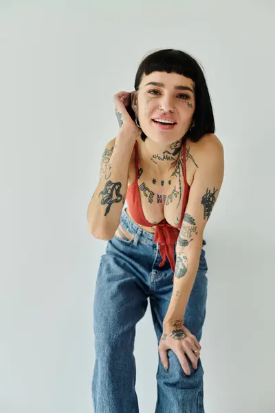 Belle femme en tenue à la mode pose ludique, mettant en valeur ses tatouages. — Photo de stock