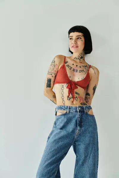 A young woman confidently showcasing her tattoos in trendy attire. — Stock Photo