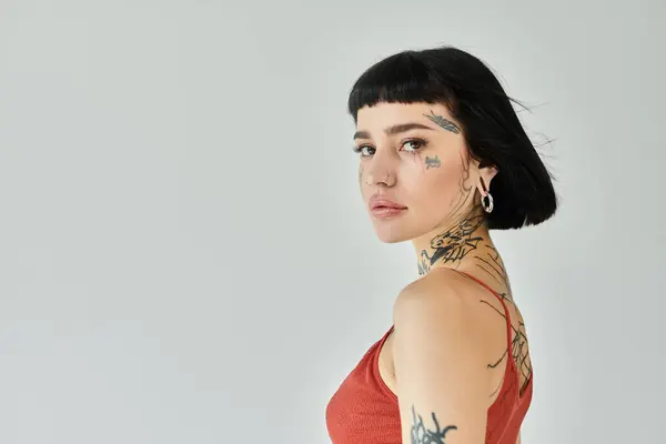 A stylish young woman showcases her unique tattoos with confidence. — Stock Photo