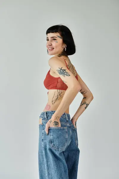 A confident woman models trendy attire, revealing artistic body ink. — Stock Photo