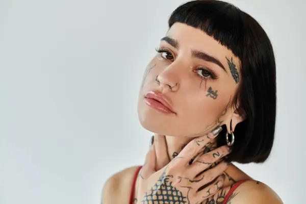 A young woman flaunts her stylish attire while highlighting her unique tattoos. — Stock Photo