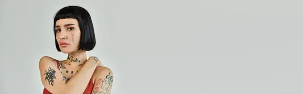 Eine junge Frau zeigt ihre Tattoos und trendiges Outfit. — Stock Photo