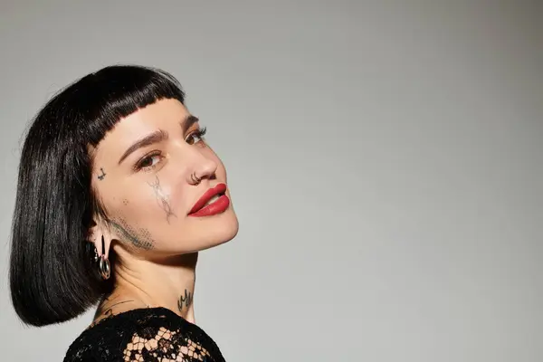 A stylish woman with striking tattoos poses confidently, exuding artistic flair. — Stock Photo