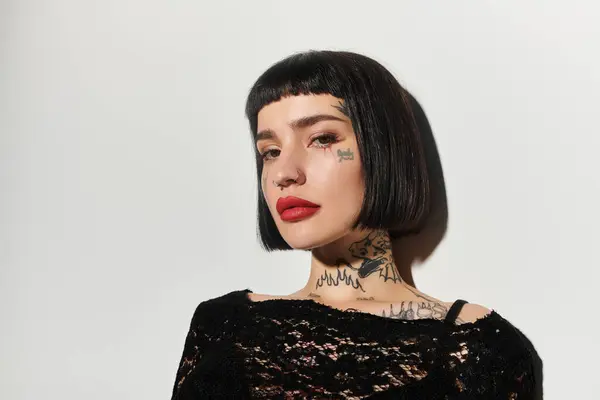Una joven con estilo posa con confianza, destacando sus tatuajes. - foto de stock