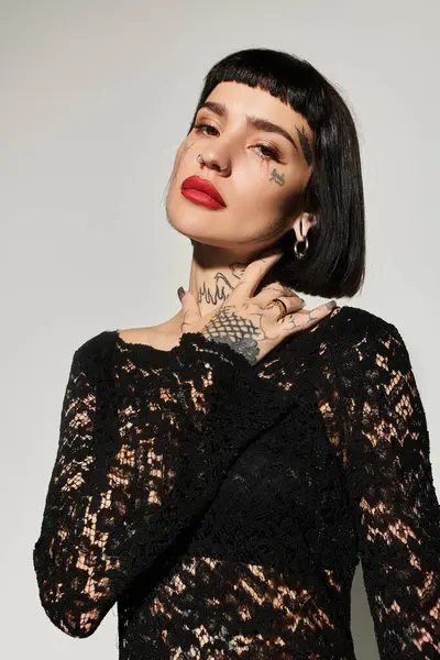 Una mujer tatuada muestra su sentido de la moda con elegancia y actitud. - foto de stock