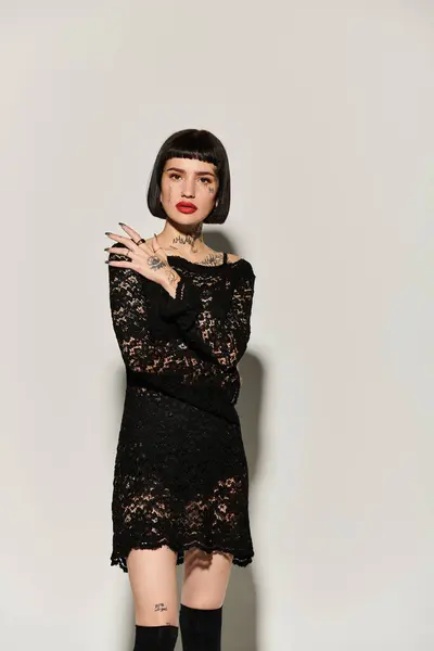 A fashionable young woman poses confidently showcasing her tattoos. — Stock Photo