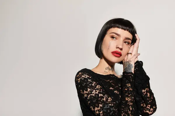 Una mujer joven de moda muestra sus impresionantes tatuajes y estilo audaz. — Stock Photo