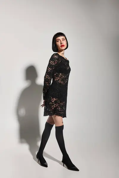 A fashionable young woman poses confidently in elegant black lace. — Stock Photo