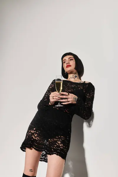 A fashionable woman poses confidently holding a glass of champagne. — Stock Photo