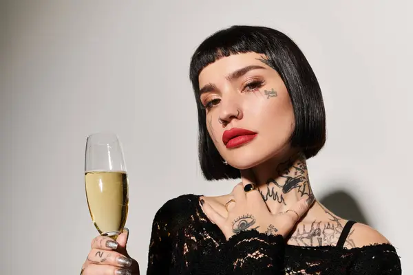 Una mujer de moda posa con confianza, sosteniendo un vaso de burbujas. - foto de stock
