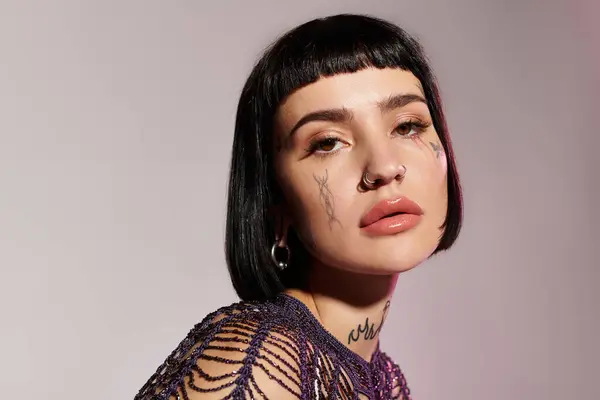 Una joven mujer emana confianza con tatuajes llamativos y moda vanguardista. - foto de stock