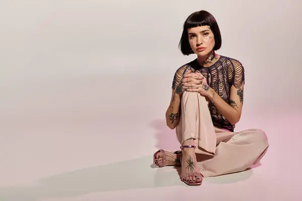 A fashionable woman with tattoos showcases her unique style while seated gracefully. — Stock Photo