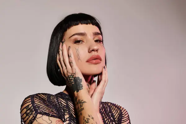 Una donna alla moda mette in mostra i suoi tatuaggi mentre colpisce una posa alla moda. — Foto stock