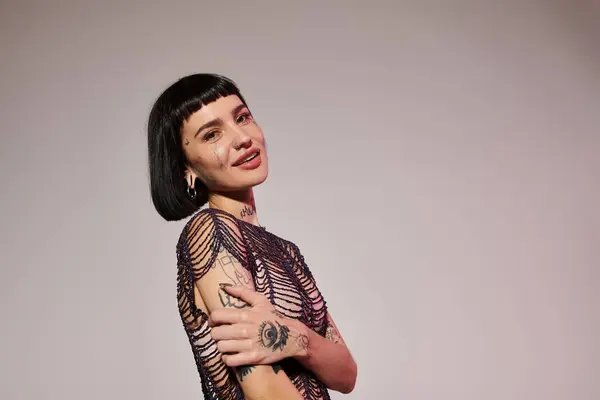 A fashionable young woman with tattoos showcases her unique style confidently. — Stock Photo