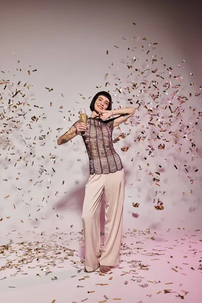 A stylish woman joyfully dances amidst falling confetti. — Stock Photo