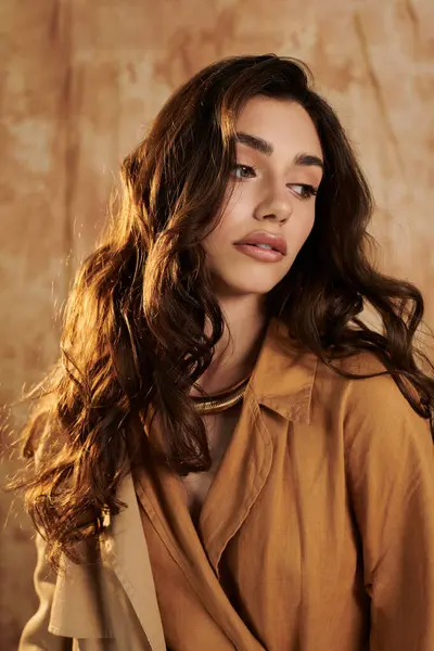 A young woman poses gracefully in a chic autumn outfit, embodying seasonal elegance within a warm studio ambiance. — Stock Photo