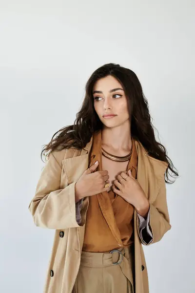 Una joven mujer exuda elegancia en un elegante traje de otoño, bellamente capturado en un entorno de estudio brillante. — Stock Photo