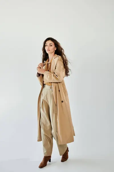 A beautiful young woman models a trendy autumn outfit, showcasing her unique style in an elegant studio environment. — Stock Photo