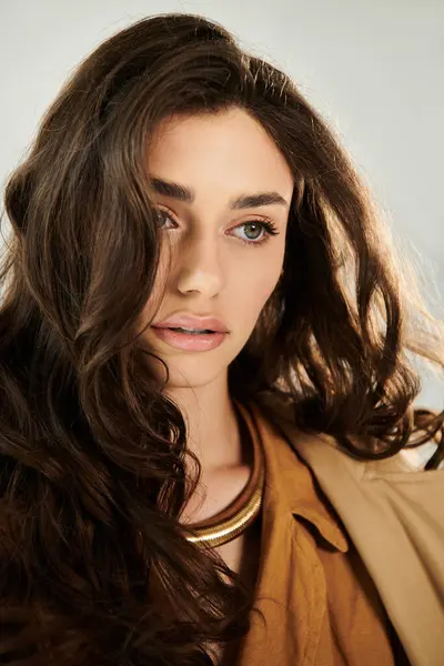 A young woman showcases her stylish autumnal outfit, posing elegantly in a warm and inviting studio space. — Stock Photo