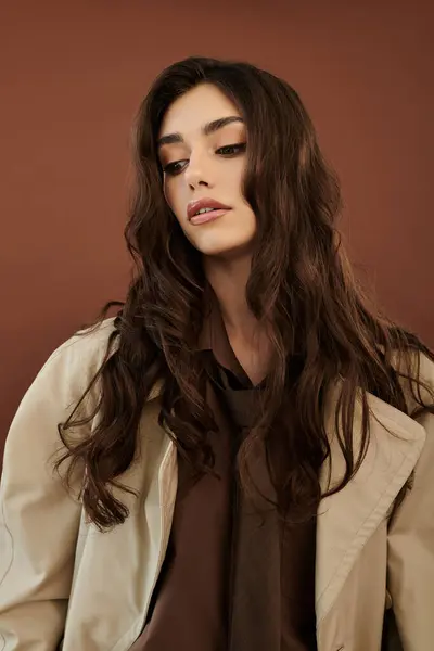 Abbracciando lo spirito autunnale, una giovane donna mette in mostra un elegante ensemble autunnale in mezzo a uno scenario di studio dai toni caldi. — Foto stock