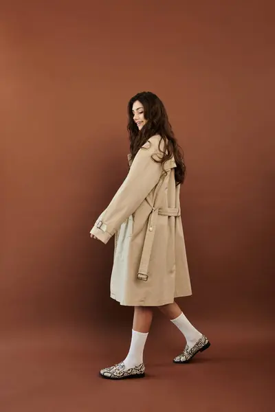 A young woman elegantly poses in a trendy autumn outfit, capturing the essence of seasonal fashion in a cozy studio atmosphere. — Stock Photo