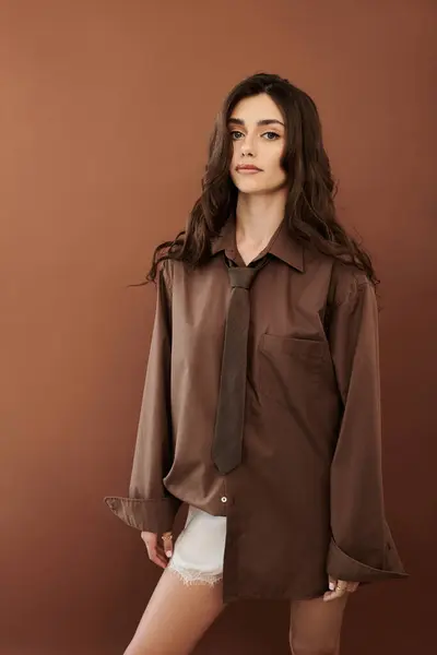 A young woman showcases her stylish autumn outfit, exuding confidence in a cozy studio ambiance. — Stock Photo