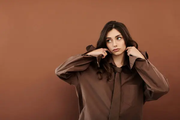 Une jeune, belle femme modèle une tenue d'automne chic dans un studio chaleureux, respirant le style et la confiance. — Photo de stock