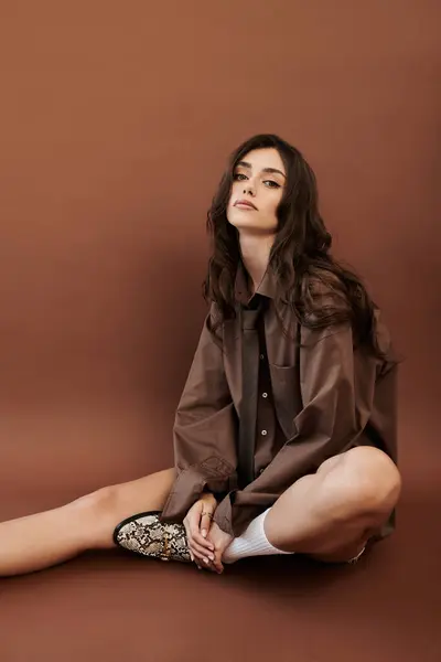 A young woman models a chic autumn outfit in a cozy studio, exuding effortless elegance and seasonal charm. — Stock Photo