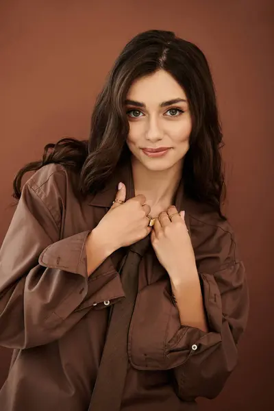 A beautiful young woman poses confidently, wearing a chic autumn outfit in a welcoming studio environment. — Stock Photo