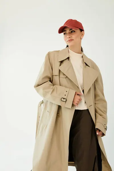 Eine junge Frau posiert selbstbewusst in einem schicken Herbst-Outfit und verkörpert saisonale Eleganz in einer stilvollen Studiokulisse. — Stockfoto
