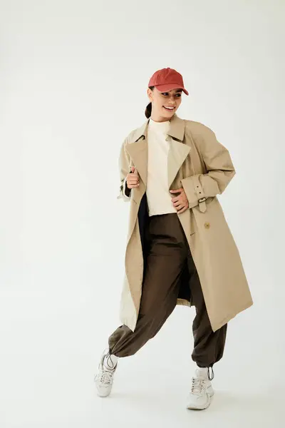 A young woman poses confidently in a trendy autumn outfit, embodying the spirit of fall in a serene studio environment. — Stock Photo