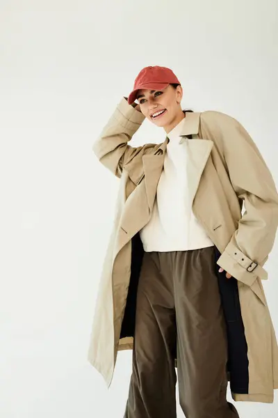 A young woman expresses her creativity in a chic autumn ensemble, exuding confidence in a modern studio setting. — Stock Photo