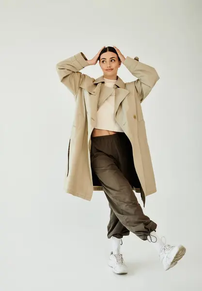 A young and beautiful woman poses confidently in a stylish autumn outfit, highlighting contemporary fashion trends. — Stock Photo