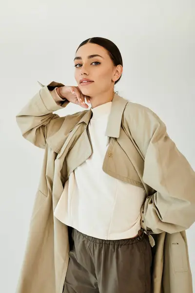 Una mujer joven posa con confianza en un traje de otoño elegante, abrazando el estilo estacional en un estudio contemporáneo. - foto de stock
