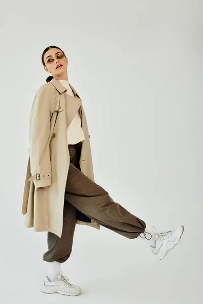 En un estudio moderno, una joven mujer toma una pose, haciendo alarde de su traje de otoño de moda con confianza y estilo. — Stock Photo