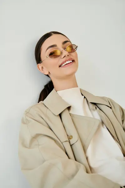 Una joven elegante y segura de sí misma exhibe su elegante atuendo otoñal en un ambiente de estudio de moda, encarnando la moda estacional. — Stock Photo