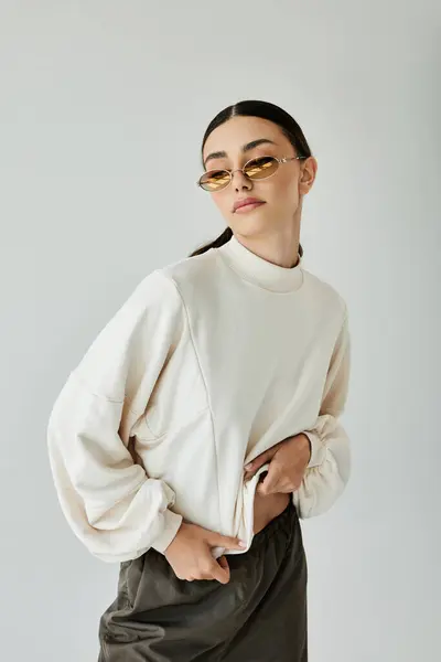 A fashionable young woman poses elegantly in a chic autumn outfit, capturing the essence of seasonal style in a studio. — Stock Photo