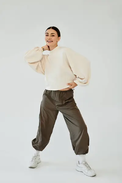 In uno studio vivace, una giovane donna irradia fiducia mentre mostra il suo elegante ensemble autunnale. — Foto stock