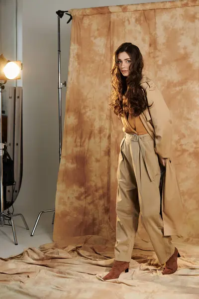A young and beautiful woman poses confidently in a chic autumn outfit, radiating warmth in a cozy studio. — Stock Photo